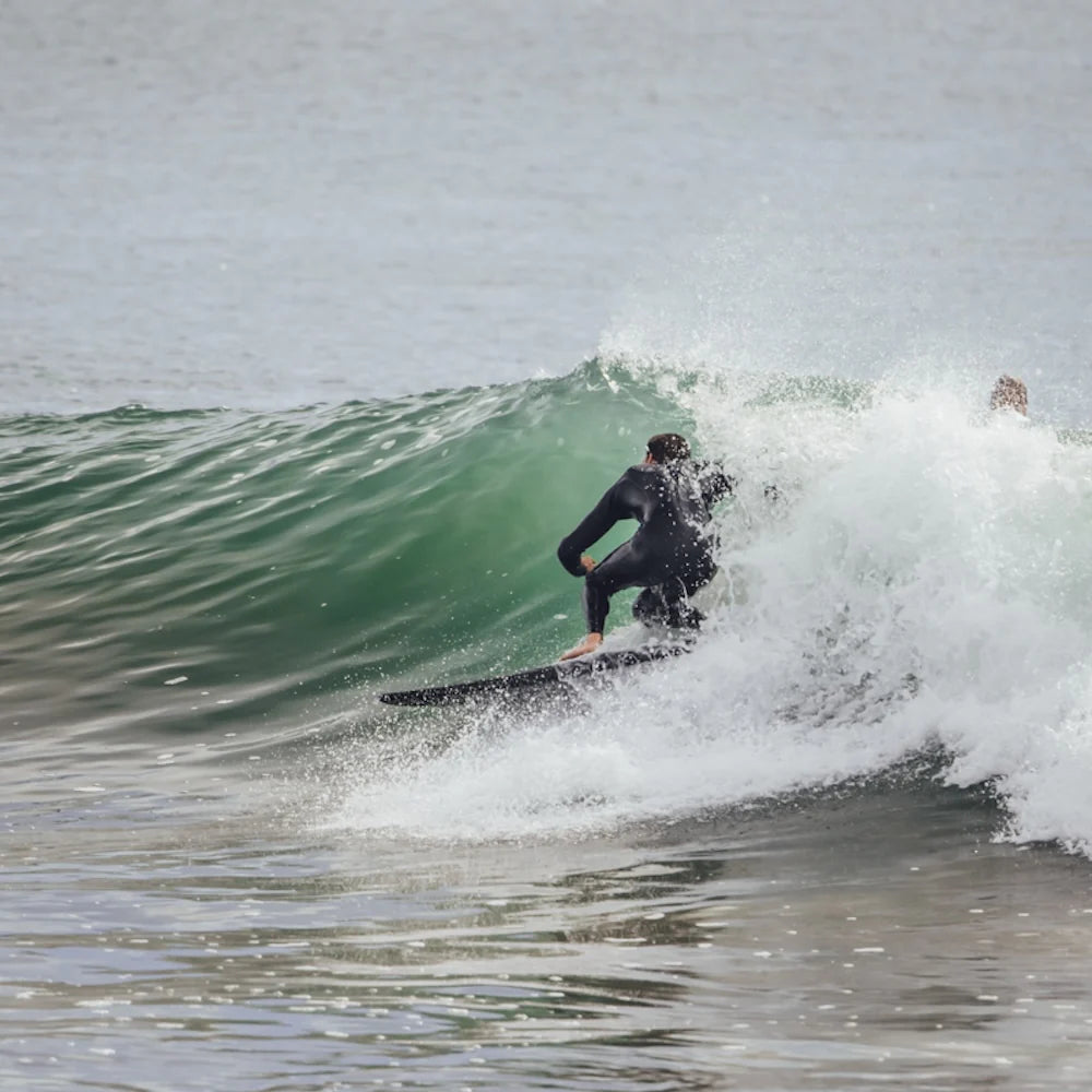 Person surfing on a wave in a wetsuit