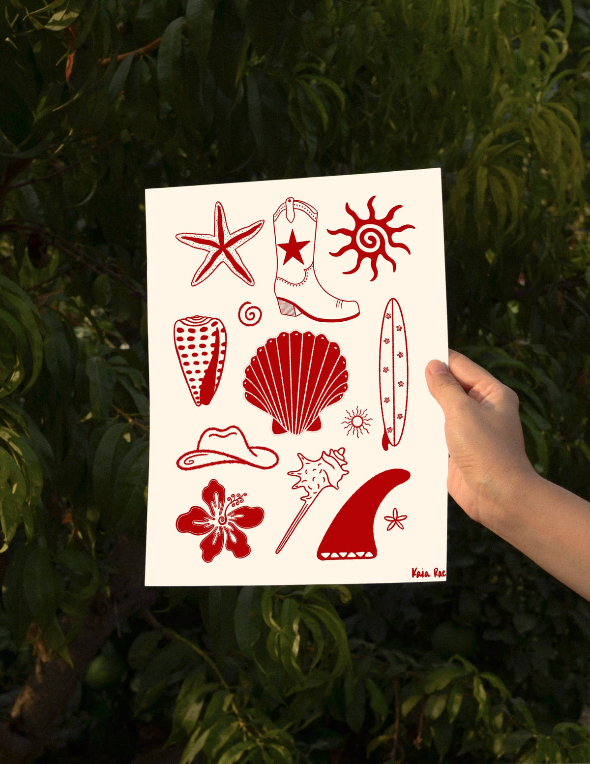 Sheet of red temporary tattoos held against a green leafy background
