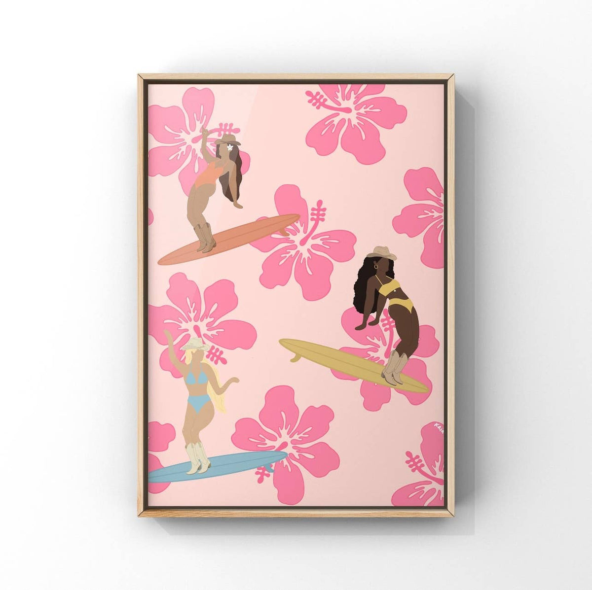 Framed wall art featuring a retro-style illustration of three women surfing on colorful boards against a pink background with large hibiscus flowers.