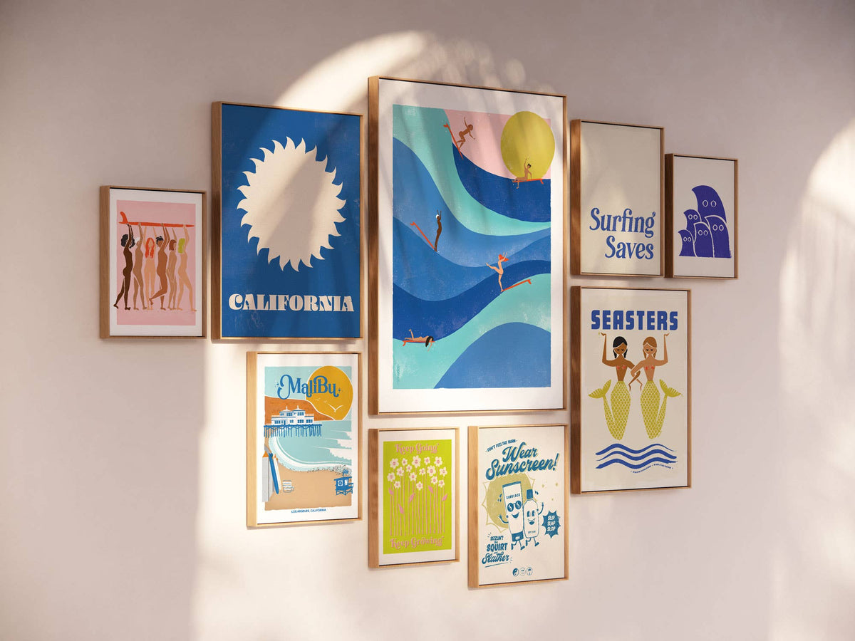 Collection of framed posters on a wall with various designs and colors.