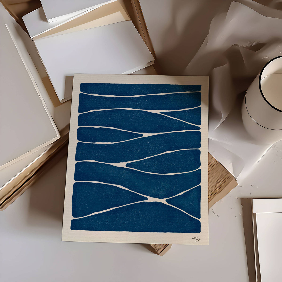 Blue abstract patterned card on a surface with books and a white mug.