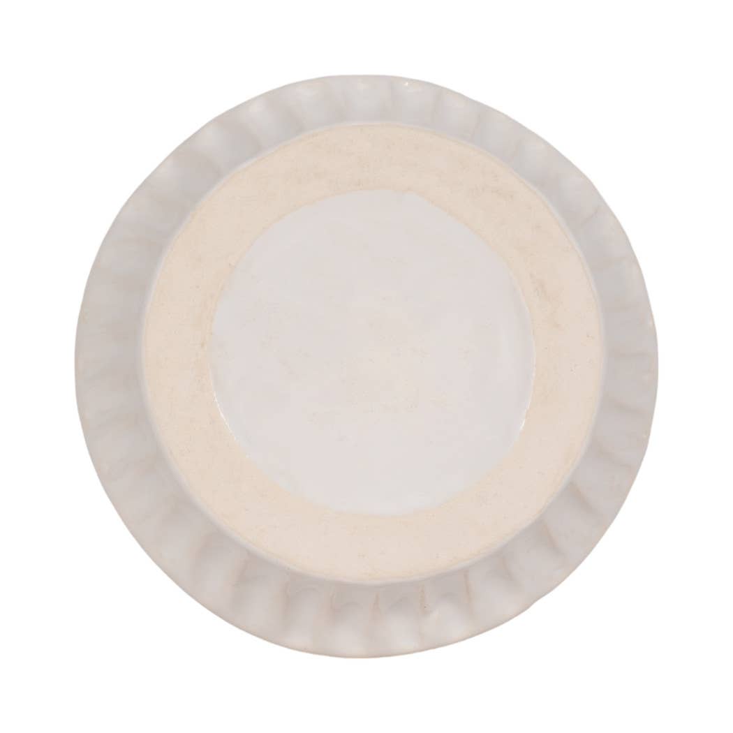 A round ceramic plate with a fluted rim, shown from a top-down view on a solid white background.
