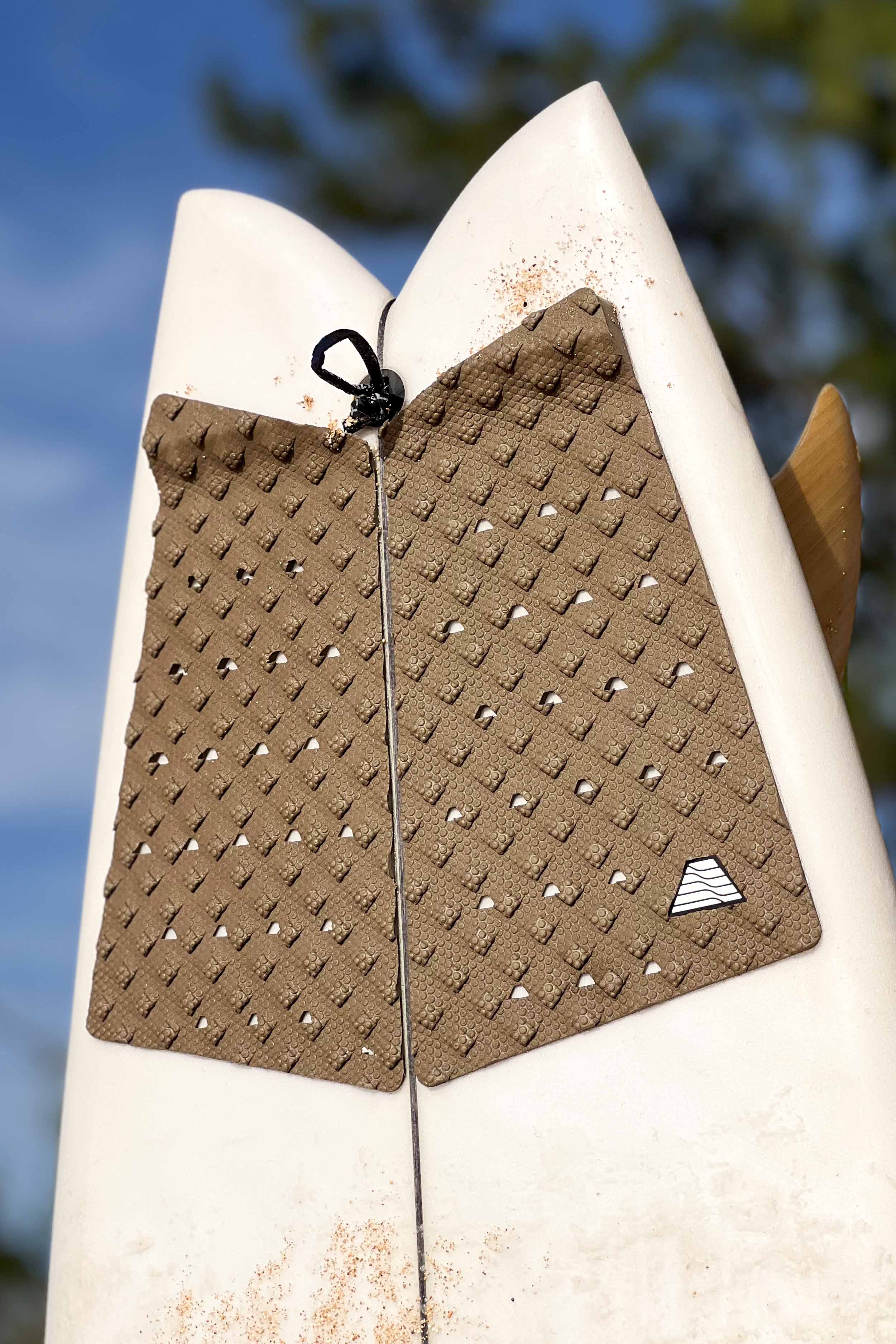 A white surfboard with VEIA Explorer 3-Piece Fish Tail Traction Pad