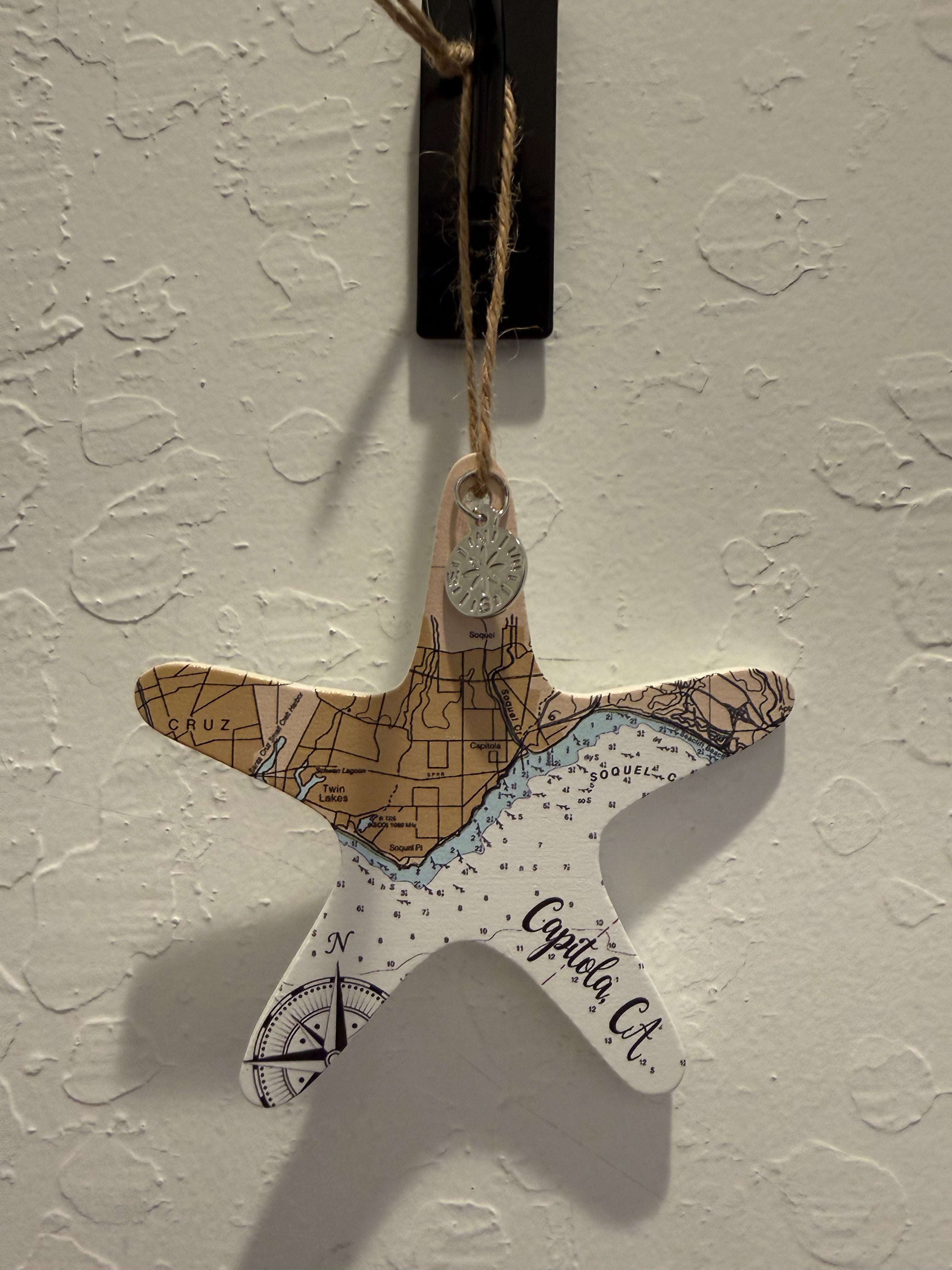 A starfish-shaped hanging ornament featuring a map design with 'Capita C.A.