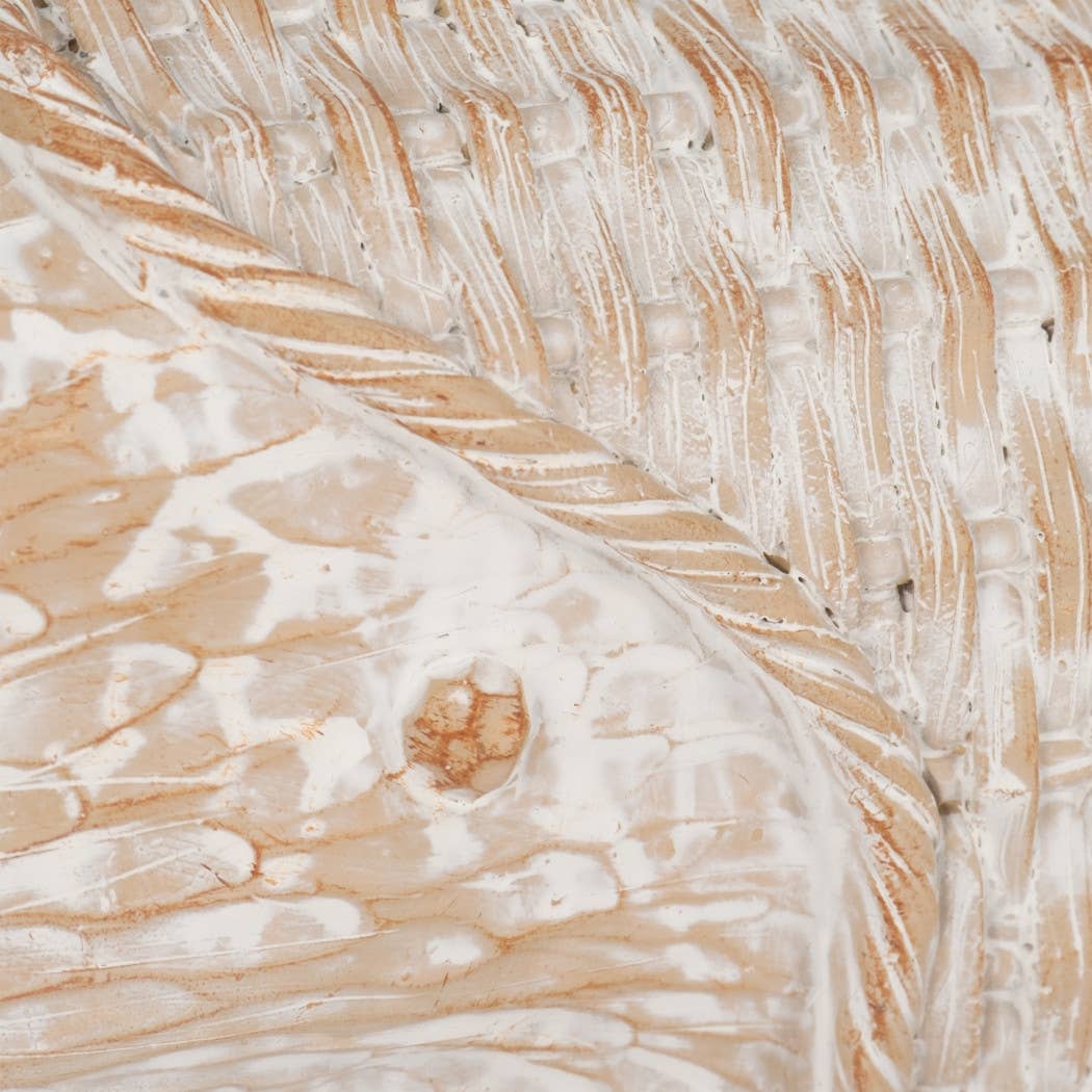 A close-up of a textured surface with a woven or ribbed pattern in warm beige/tan and white, showing a small oval defect or hole near the center.
