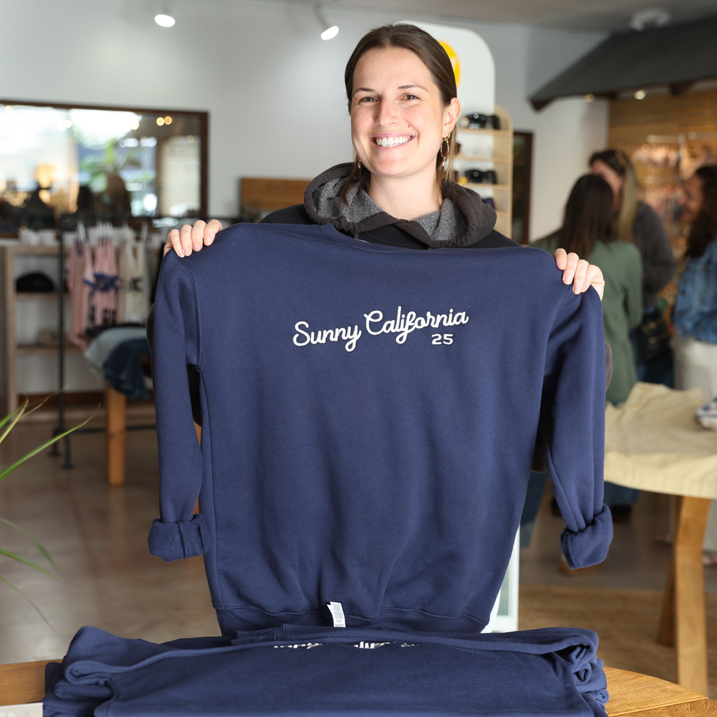 Friendly staff holding up Sunny California sweatshirt