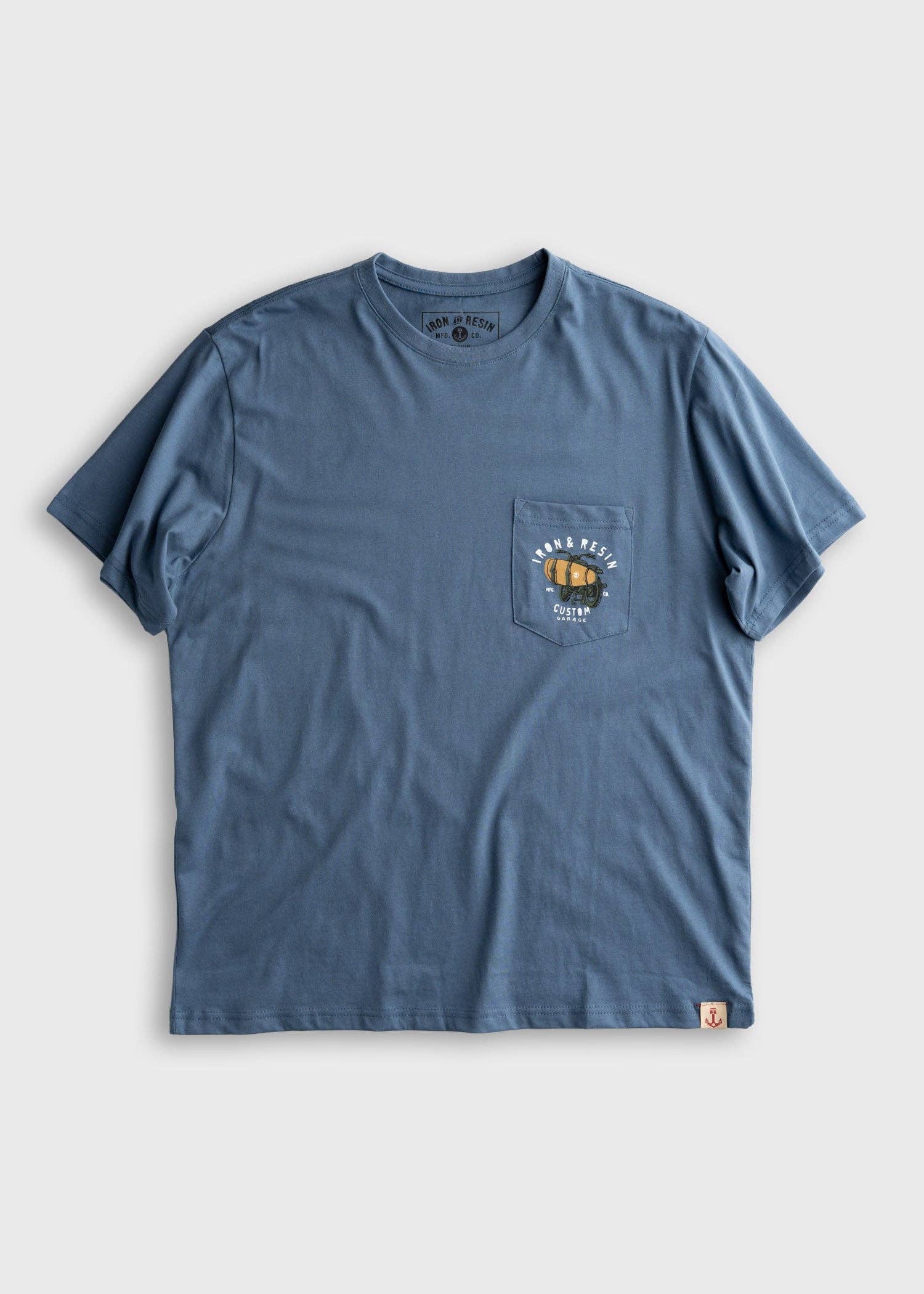 Blue t-shirt with a pocket and graphic on a light gray background