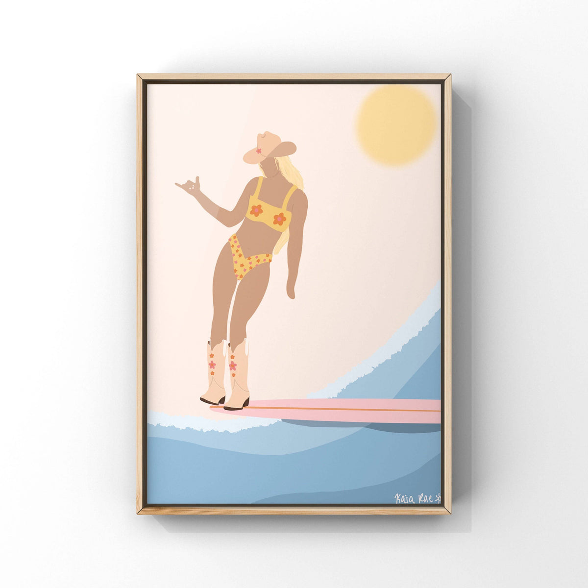 Framed artwork of a woman in a swimsuit standing on a surfboard with a wave and sun in the background.