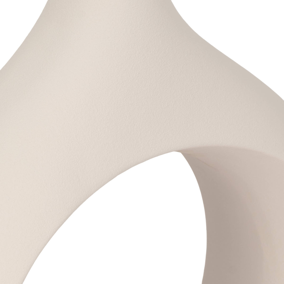 A close-up of a smooth, matte off-white ceramic or stone object with a curved, sculptural form against a white background.