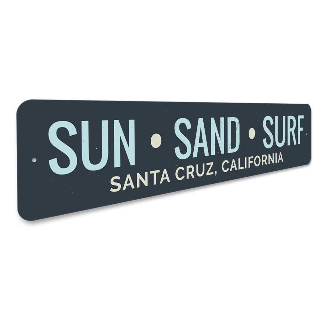 Decorative sign with 'Sun Sand Surf Santa Cruz, California' text on a black background