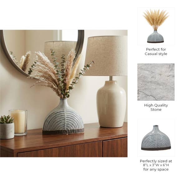 A decorative vase with a gray and white striped arched pattern, styled in a home interior setting on a wooden console table next to a lamp and dried grasses. On the right, three text callouts describe the vase's features: 'Perfect for Casual style', 'High Quality Stone', and 'Perfectly sized at 8"L x 3"W x 6"H for any space'.