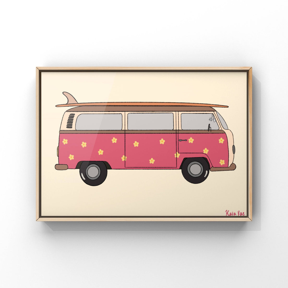 Framed wall art featuring a retro pink van with yellow flowers and a surfboard on top, shown in a thin wood frame against a light gray wall.