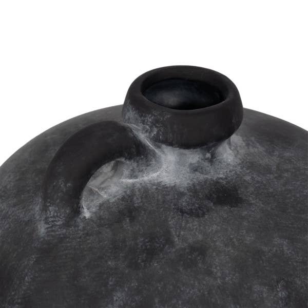 Close-up of a textured black vase on a white background