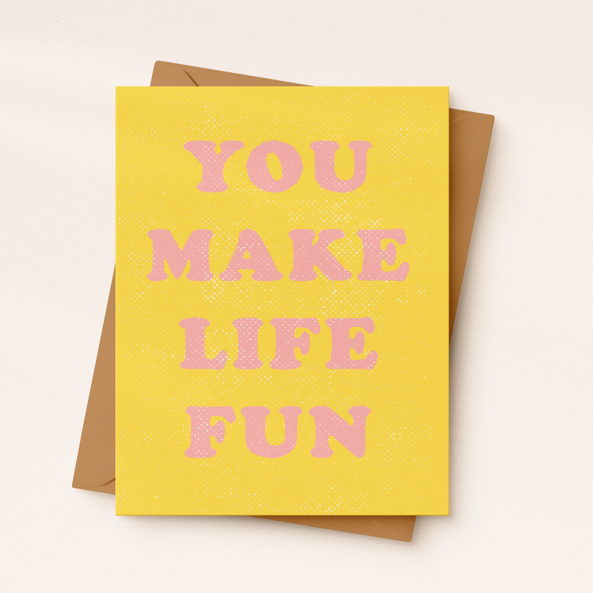 Yellow card with pink text 'YOU MAKE LIFE FUN' on a beige background