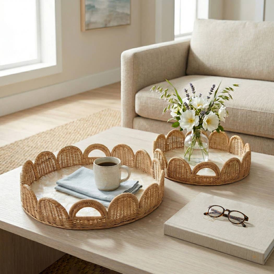 Wicker trays on a coffee table with a cup, glasses, and flowers in a living room.
