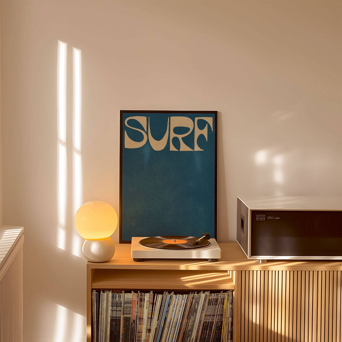 Record player with vinyl records and a 'Surf' framed picture on a shelf.