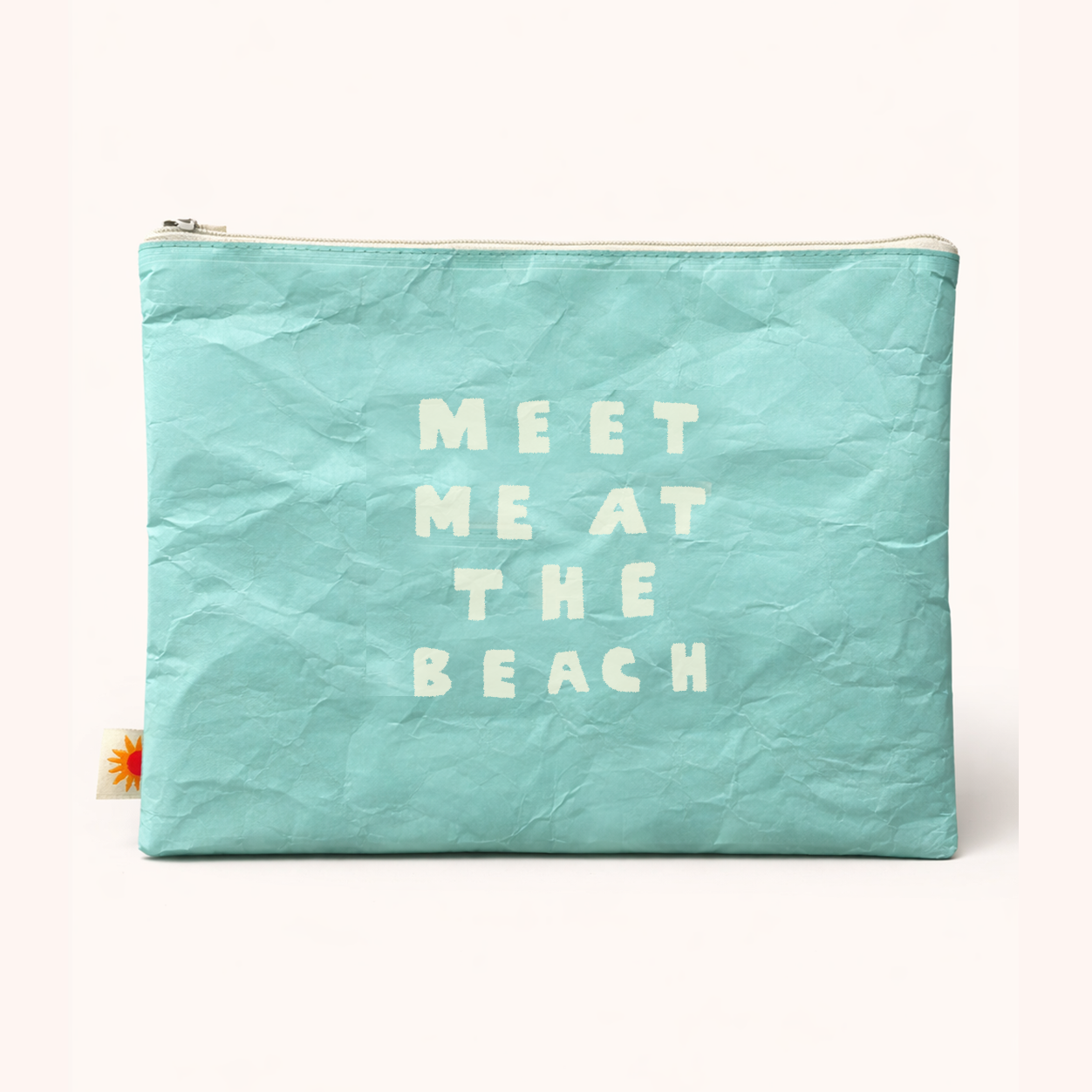 Turquoise pouch with 'Meet Me at the Beach' text on a white background