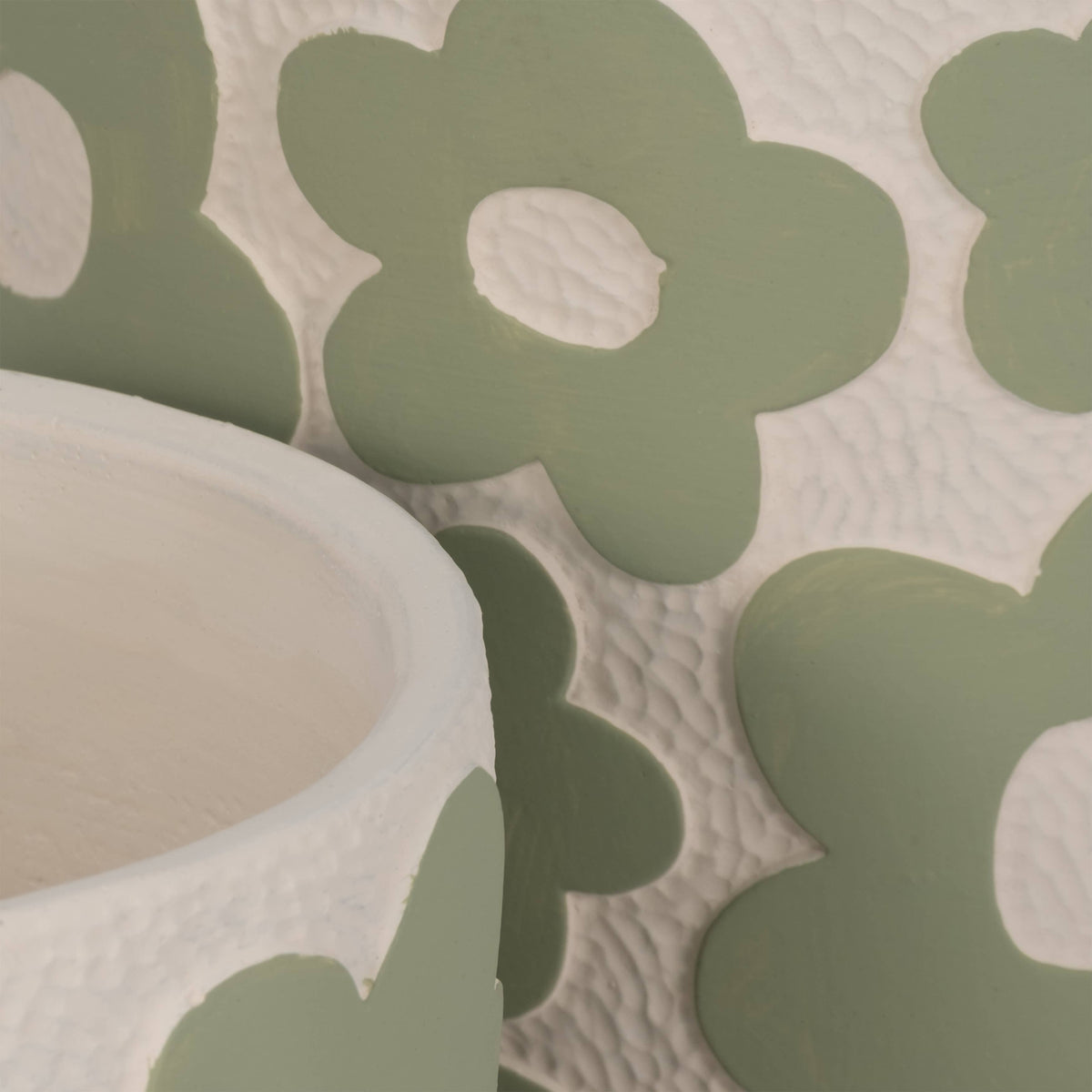 Close-up of a green floral coaster with a textured surface