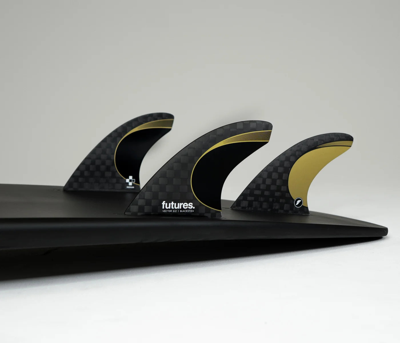 Black surfboard with Futures Vector 3/2 Blackstix+ Medium Thruster Fin Set