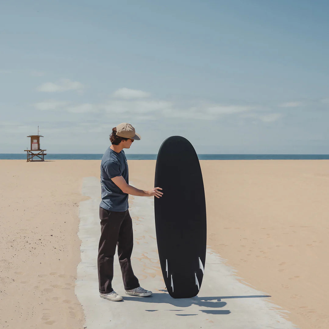 person holding 5’4 R-Series Secret Menu surfboard by Almond on the beach