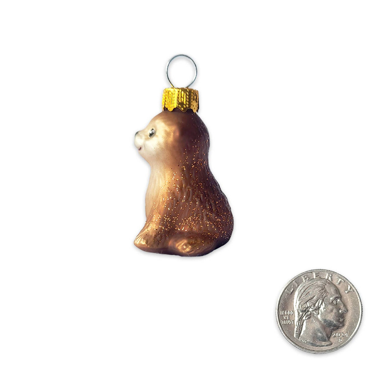 A small brown and gold glitter Christmas ornament shaped like a beaver or squirrel, shown on a white background with a U.S.