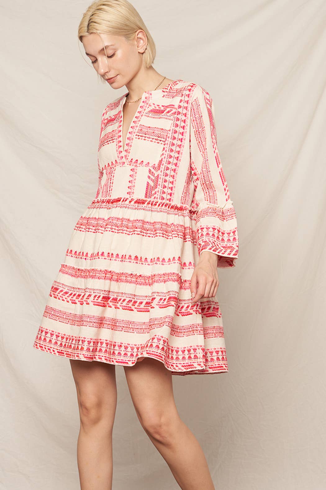 Woman wearing a red and white patterned dress on a beige background