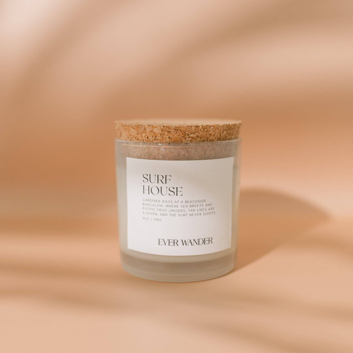 Candle with cork lid and 'Ever Wander' label on a beige background