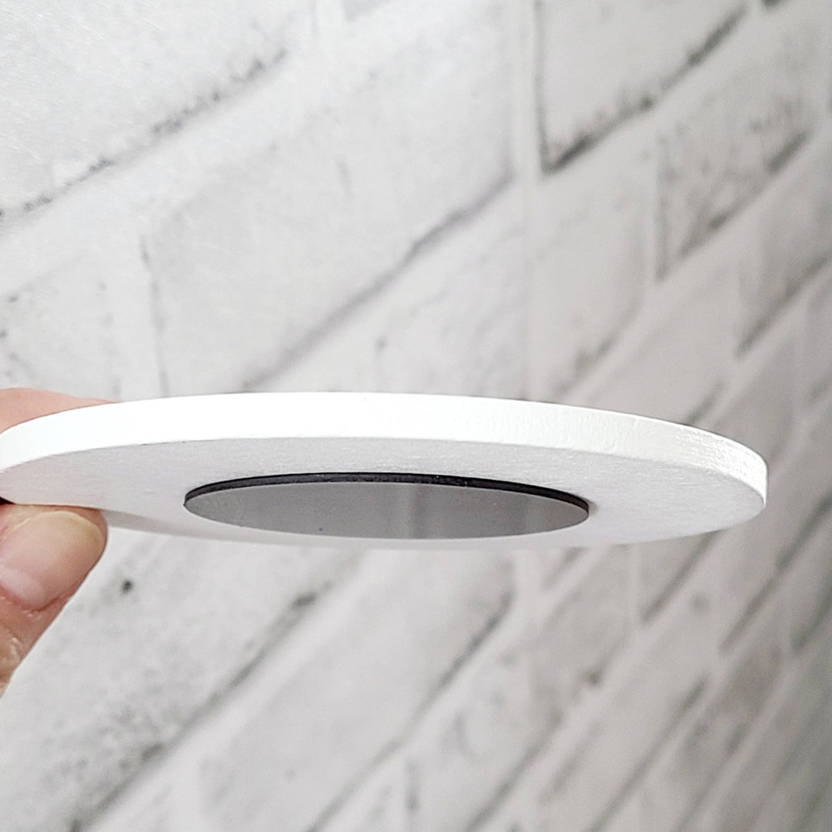 White circular object held against a marble background