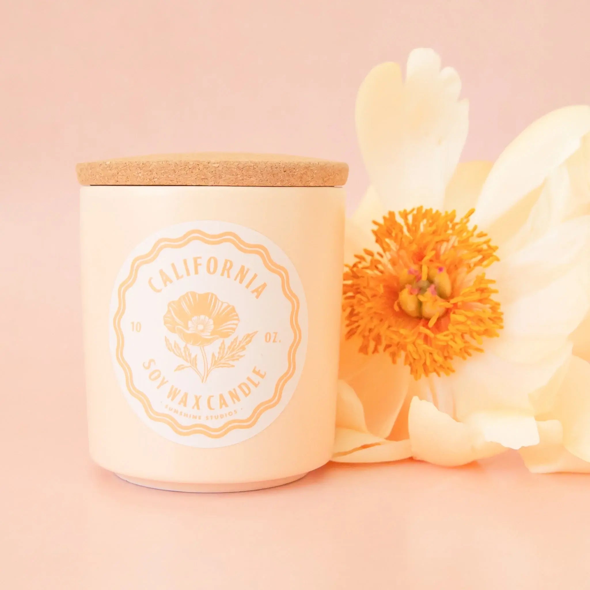 Candle with a wooden lid and floral design on a pink background