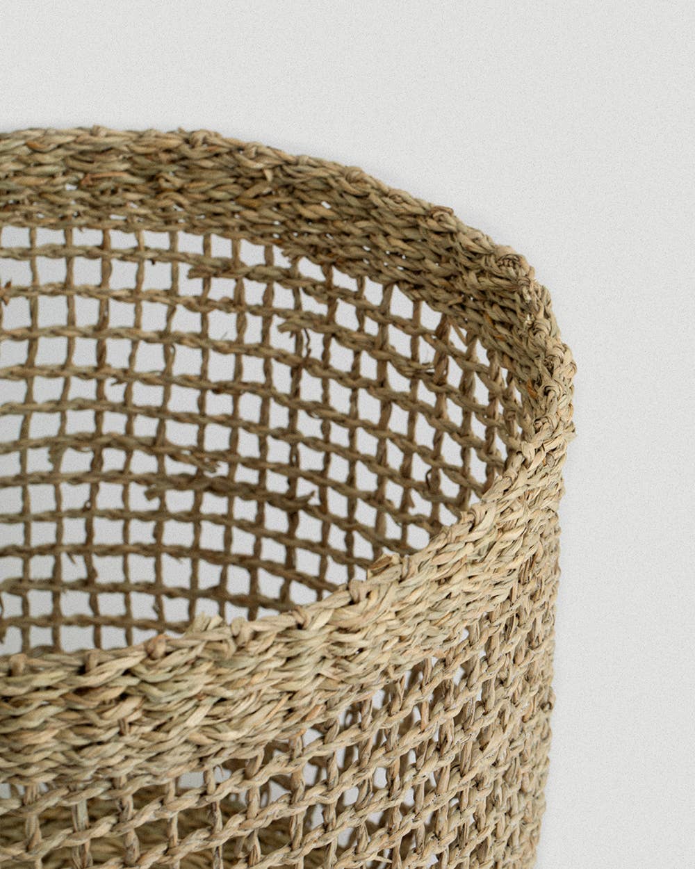 Close-up of a woven seagrass basket on a light gray background