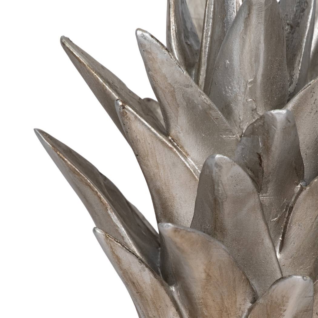 Metallic silver plant-like sculpture on a white background