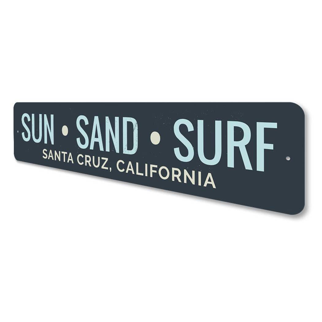 Decorative sign with 'Sun Sand Surf Santa Cruz, California' text on a white background