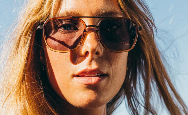 Person wearing sunglasses with a clear blue sky background
